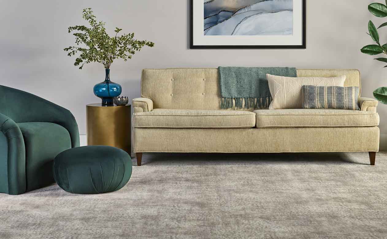 Living room with soft grey and cream furniture and carpet.