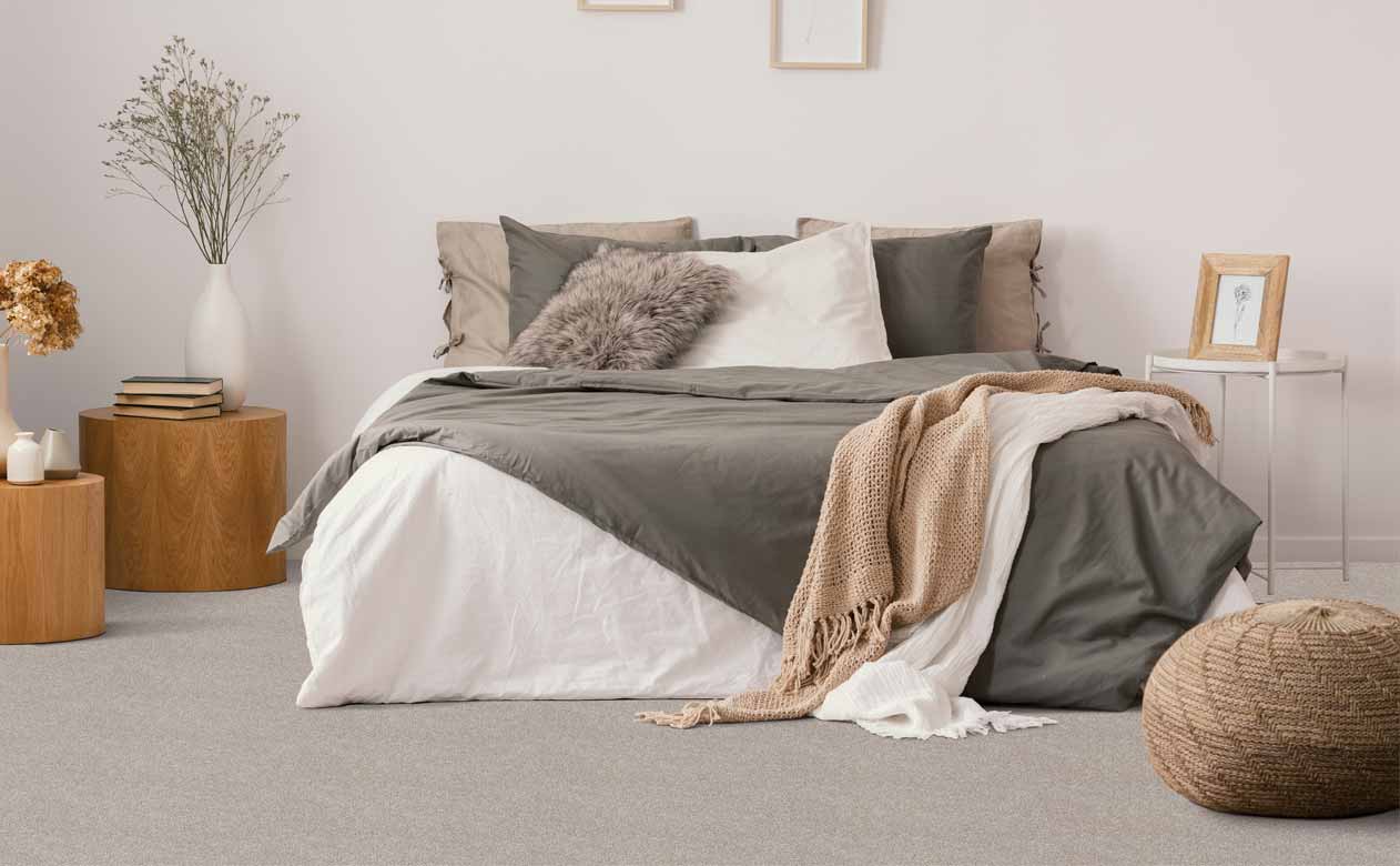grey carpet in a bedroom with wooden accent tables