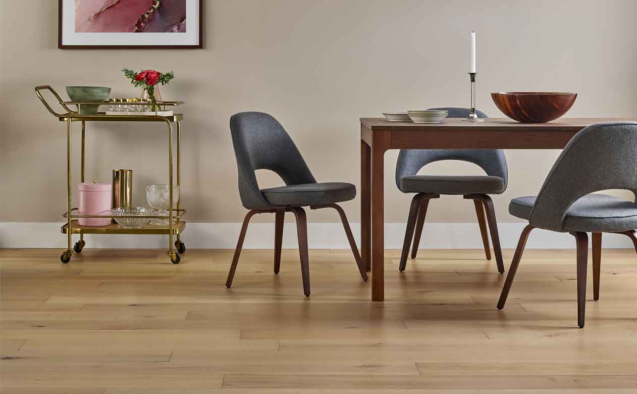hardwood flooring with brown table and three blue chairs. 